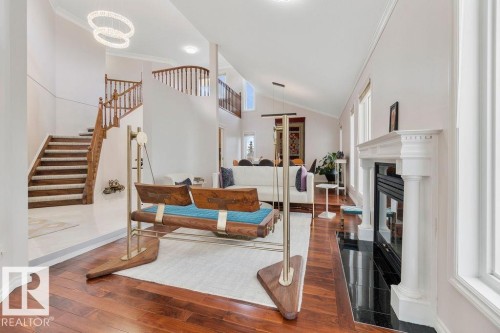 Two-story foyer with a grand staircase and wrought iron balusters - 956 Ogilvie Boulevard, Edmonton, AB - Indoor Photo Showing Other Room With Fireplace