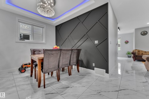 Dining area featuring a geometric accent wall, recessed ceiling lighting, and a prominent chandelier - 1827 22 Street Nw, Edmonton, AB - Indoor
