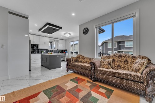 Open-concept living space with large windows, recessed lighting, and white tile flooring - 1827 22 Street Nw, Edmonton, AB - Indoor Photo Showing Living Room