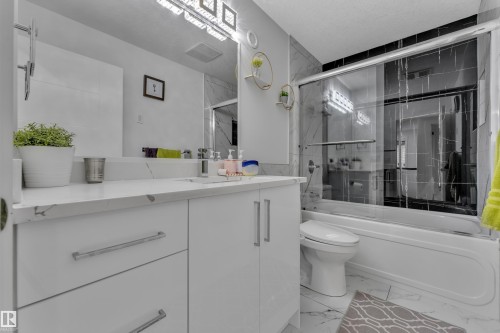 Bathroom featuring a white vanity with brushed nickel hardware, a white countertop, and an undermount sink - 1827 22 Street Nw, Edmonton, AB - Indoor Photo Showing Bathroom