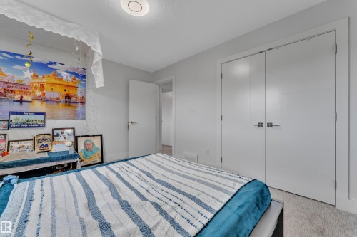 Bedroom featuring light gray wall paint, a built-in closet with double doors, white trim, and a flush-mount ceiling light - 1827 22 Street Nw, Edmonton, AB - Indoor Photo Showing Bedroom