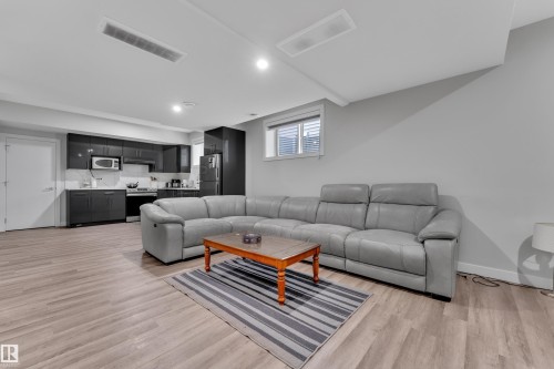Open-concept living space featuring wood-finish flooring, recessed lighting, and a window with horizontal blinds - 1827 22 Street Nw, Edmonton, AB - Indoor Photo Showing Living Room