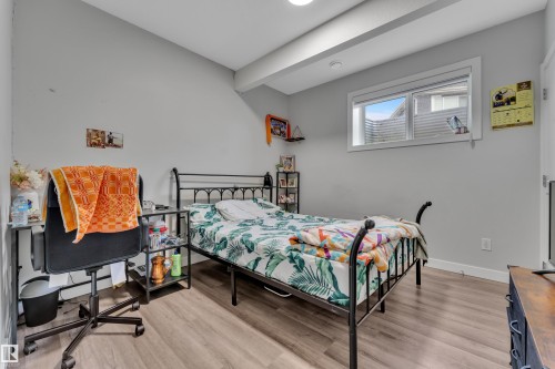 Bedroom featuring wood-finish flooring, a window with white trim, and light gray walls - 1827 22 Street Nw, Edmonton, AB - Indoor Photo Showing Bedroom