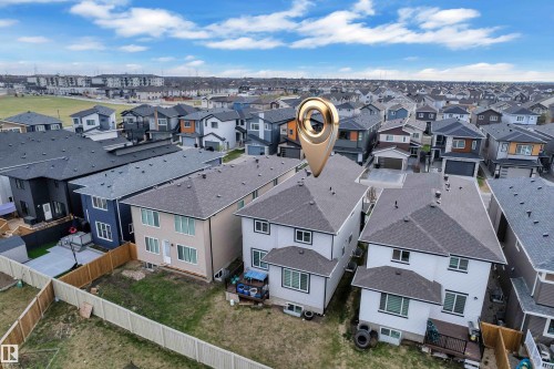Rear exterior featuring a ground-level deck, fenced backyard, and established neighboring properties - 1827 22 Street Nw, Edmonton, AB - Outdoor