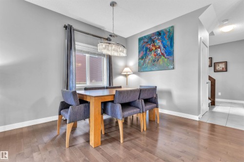 This property features dark wood flooring, light grey painted walls, and white trim - 8108 217 Street, Edmonton, AB - Indoor Photo Showing Dining Room