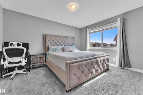 This room features a window with a view of houses, light grey carpet, and light grey walls - 8108 217 Street, Edmonton, AB - Indoor Photo Showing Bedroom