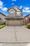 The property features a two-story exterior with a combination of siding and stone detailing, a prominent double garage, and a concrete driveway - 8108 217 Street, Edmonton, AB  - Outdoor 