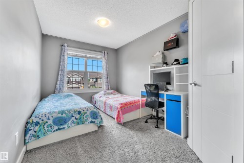 Bedroom featuring a window with patterned curtains, light grey walls, and grey carpet flooring - 8108 217 Street, Edmonton, AB - Indoor Photo Showing Bedroom