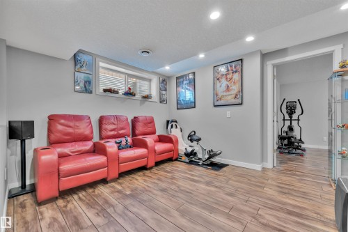 Recreational space featuring wood-look flooring, recessed lighting, and a window with horizontal blinds - 8108 217 Street, Edmonton, AB - Indoor