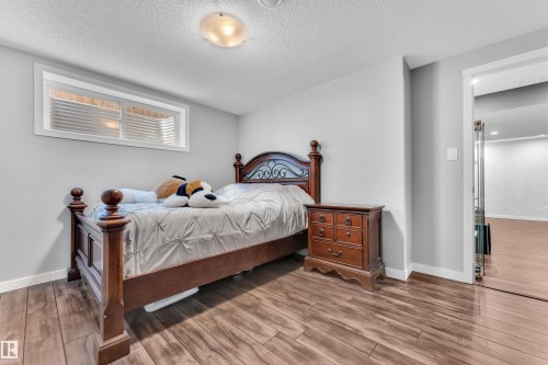 Bedroom featuring light gray walls, a window with blinds, and wood flooring - 8108 217 Street, Edmonton, AB - Indoor Photo Showing Bedroom