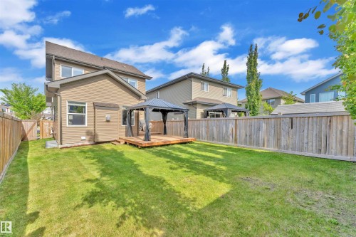 The property includes a spacious lawn, a wooden deck, and a gazebo - 8108 217 Street, Edmonton, AB - Outdoor With Deck Patio Veranda