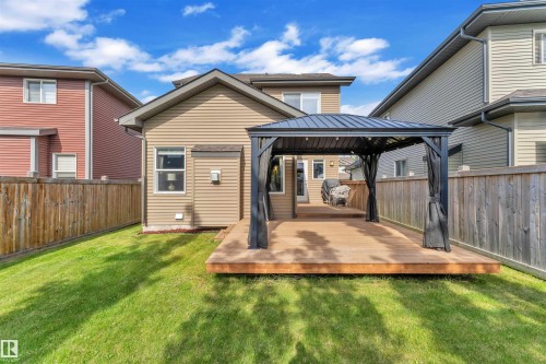 The property features a spacious backyard with a well-maintained lawn and a wooden deck - 8108 217 Street, Edmonton, AB - Outdoor With Deck Patio Veranda With Exterior