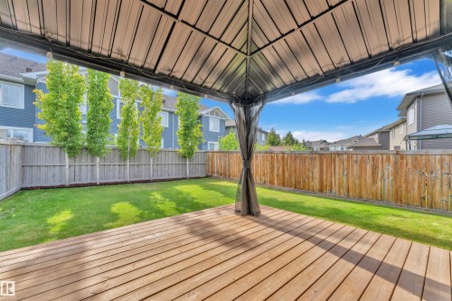 The property features a spacious wooden deck with a gazebo, overlooking a well-maintained lawn - 8108 217 Street, Edmonton, AB - Outdoor With Deck Patio Veranda With Backyard