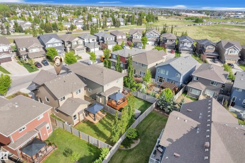 This property features a spacious backyard with a well-maintained lawn and mature trees - 8108 217 Street, Edmonton, AB - Outdoor With View