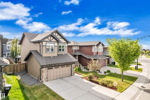 The property features a two-car garage, a concrete driveway, and a well-maintained lawn - 8108 217 Street, Edmonton, AB - Outdoor With Facade