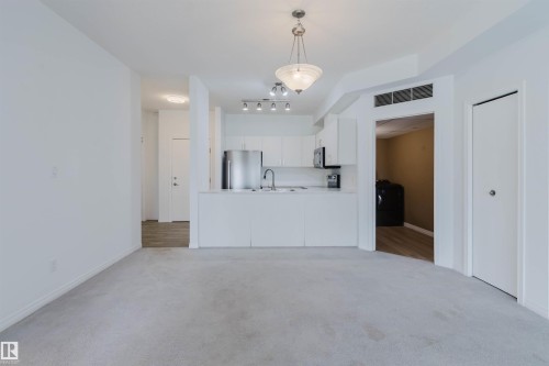 Open-concept living area with light-toned carpeting - 308 4316 139 Avenue, Edmonton, AB 