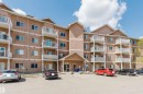 Multi-story building exterior featuring a neutral stucco finish and multiple balconies with white railings - 308 4316 139 Avenue, Edmonton, AB 