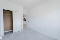 Bedroom featuring white walls, light gray carpet, and a bi-fold closet with shelving and a hanging rod - 