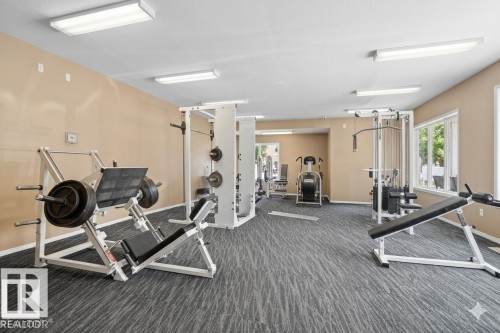 Fitness room featuring patterned grey carpeting, light beige walls, and white ceiling panels - 308 4316 139 Avenue, Edmonton, AB 
