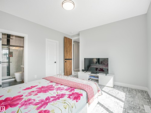 Bright interior featuring light gray walls and wood-finish flooring - 15 Elwyck Gate, Spruce Grove, AB - Indoor Photo Showing Bedroom