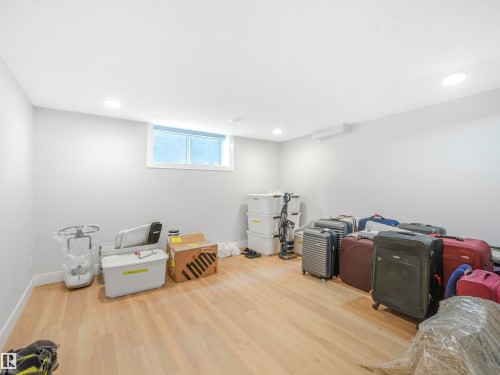 Spacious room featuring wood-finish flooring, white baseboards, and light gray walls - 15 Elwyck Gate, Spruce Grove, AB - Indoor Photo Showing Other Room