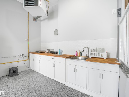 Utility space featuring speckled epoxy flooring, white cabinetry, and wood-finish countertops - 15 Elwyck Gate, Spruce Grove, AB - Indoor