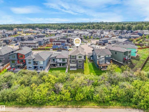 Three-story modern residence featuring a grey exterior with white trim, private rear deck, and a green space buffer - 15 Elwyck Gate, Spruce Grove, AB - Outdoor With View