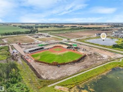 Aerial perspective showcasing a baseball stadium with green playing fields and spectator stands - 
