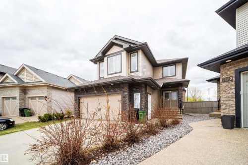 Contemporary two-story residence featuring light-colored siding and dark stone veneer accents - 1508 Cunningham Cape Cape, Edmonton, AB - Outdoor
