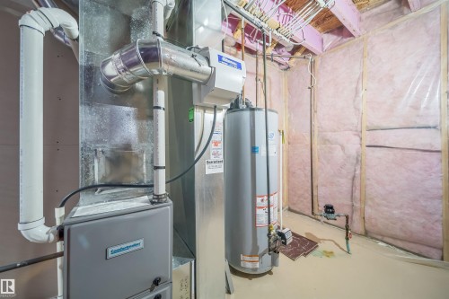 Utility area featuring a forced-air furnace, water heater, exposed ductwork, and insulated wall framing - 1508 Cunningham Cape Cape, Edmonton, AB - Indoor Photo Showing Basement
