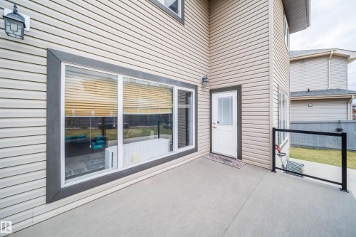 Expansive concrete patio with glass panel railing - 1508 Cunningham Cape Cape, Edmonton, AB - Outdoor With Exterior