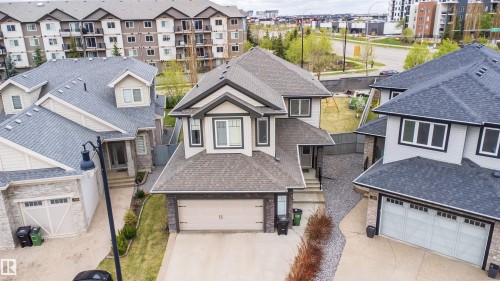 Two-story residence featuring a gabled roofline, stone and siding exterior, an attached garage, and a concrete driveway - 1508 Cunningham Cape Cape, Edmonton, AB - Outdoor With Facade