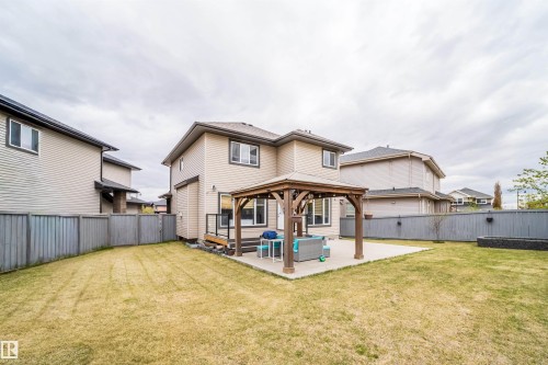 Expansive backyard featuring a concrete patio with an attached wooden gazebo, a composite deck with black metal railings, and a rectangular raised garden bed - 1508 Cunningham Cape Cape, Edmonton, AB - Outdoor With Exterior