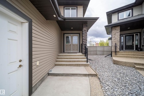 Entryway featuring a stone-clad pillar, concrete stairs, and a gravel ground cover - 1508 Cunningham Cape Cape, Edmonton, AB - Outdoor With Exterior
