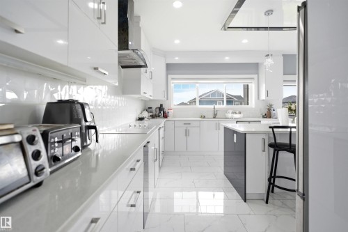 Modern kitchen with white shaker-style cabinetry, a built-in cooktop, and a matching range hood - 3909 49 Ave, Beaumont, AB - Indoor Photo Showing Kitchen With Upgraded Kitchen