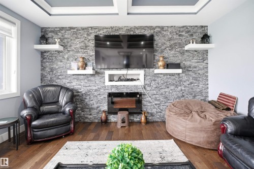 Feature wall with stacked stone finish and integrated electric fireplace - 3909 49 Ave, Beaumont, AB - Indoor Photo Showing Living Room