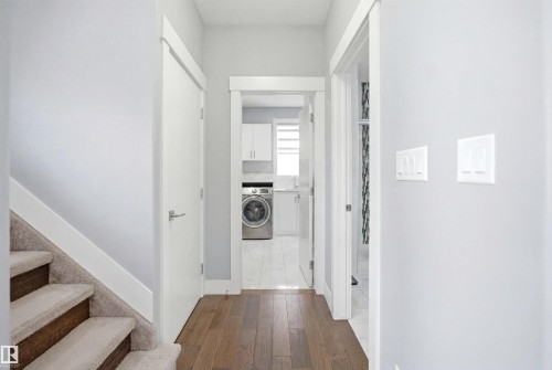 Hallway with rich wood-finish flooring and light gray walls - 3909 49 Ave, Beaumont, AB - Indoor