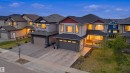 Modern two-story residence featuring light gray siding with a red accent, dark shingle roofing, and multiple windows - 3909 49 Ave, Beaumont, AB  - Outdoor With Facade 