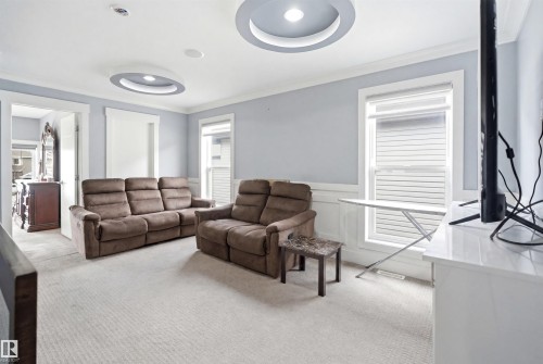 Carpeted room featuring elegant crown molding and recessed ceiling light fixtures - 3909 49 Ave, Beaumont, AB - Indoor Photo Showing Living Room