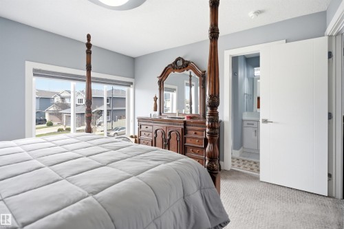 Carpeted room with light blue walls and a wide window offering exterior views - 3909 49 Ave, Beaumont, AB - Indoor Photo Showing Bedroom
