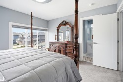 Carpeted room with light blue walls and a wide window offering exterior views - 