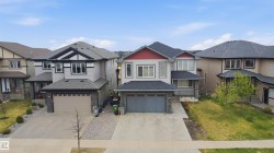 Contemporary exterior featuring light grey siding, a dark grey shingle roof, and red accent gables - 