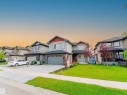 Contemporary two-story residence with a gray facade, red trim accents, and a dark shingle roof - 3909 49 Ave, Beaumont, AB  - Outdoor With Facade 