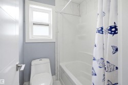 Bathroom featuring a built-in tub with a white surround, white wall tile, and a single window with white trim - 