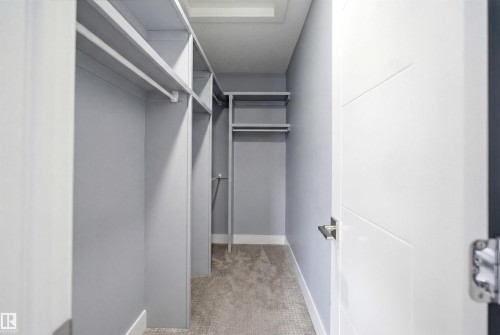Walk-in closet featuring built-in shelving, hanging rods, and light gray wall tones - 3909 49 Ave, Beaumont, AB - Indoor With Storage