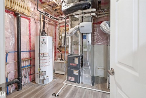 Utility room featuring a water heater, furnace, and exposed piping - 3909 49 Ave, Beaumont, AB - Indoor Photo Showing Basement