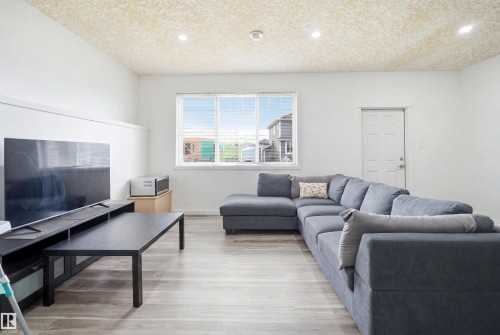 Living area featuring light wood-finish flooring and a large window - 3909 49 Ave, Beaumont, AB - Indoor Photo Showing Living Room