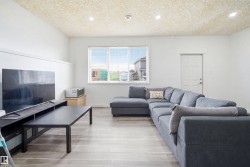 Living area featuring light wood-finish flooring and a large window - 