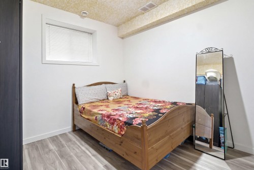 BASEMENT ROOM 1- Room with light wood-finish flooring, white walls, and a textured ceiling - 3909 49 Ave, Beaumont, AB - Indoor Photo Showing Bedroom