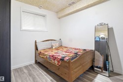 BASEMENT ROOM 1- Room with light wood-finish flooring, white walls, and a textured ceiling - 